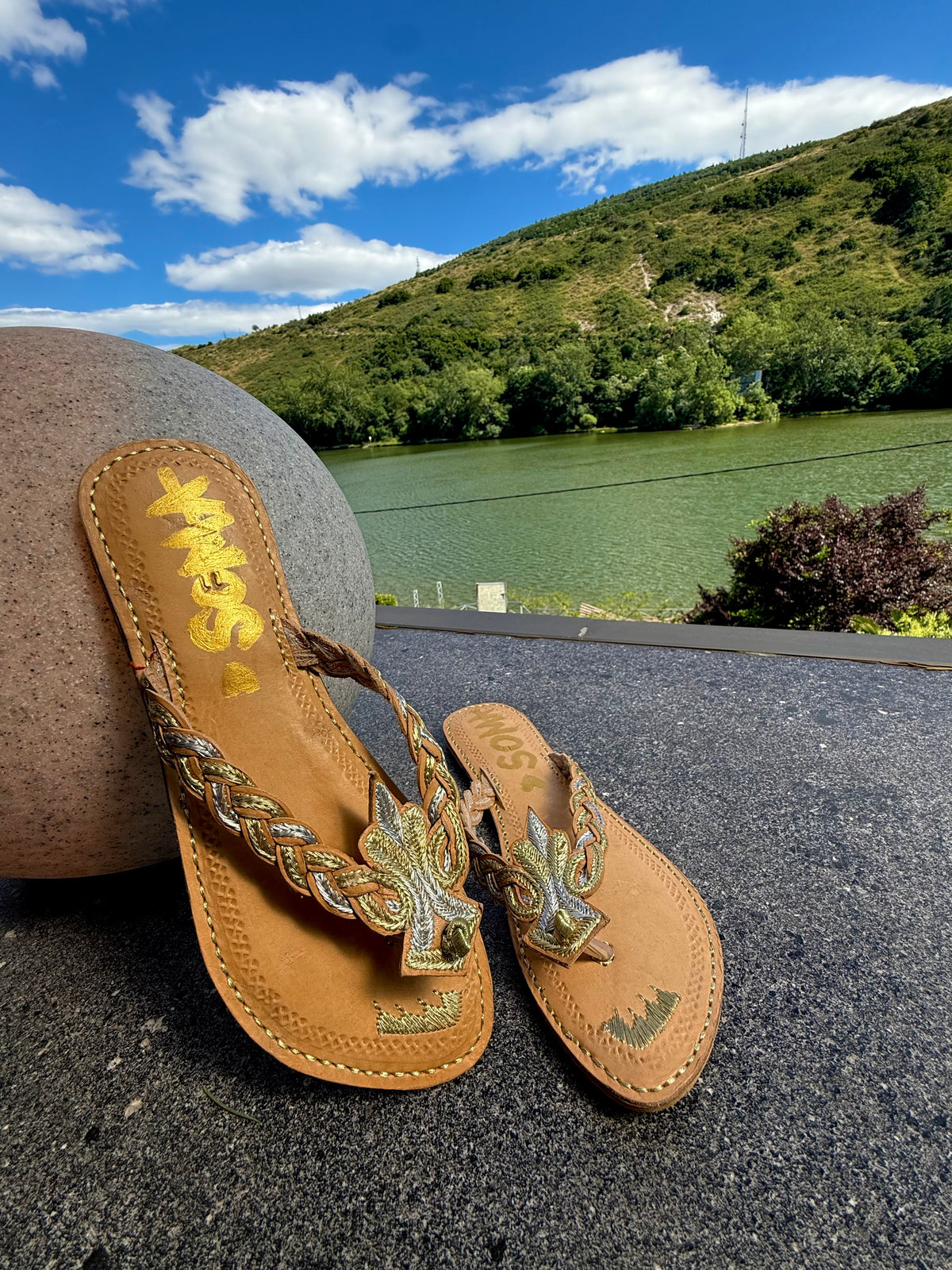 Noori handmade leather sandals by SOMA, styled outdoors by a lake
